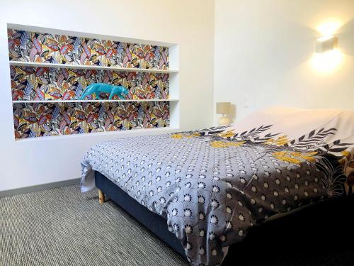 a bedroom with a bed with a colorful wall at Manoir de la Haute Couplais in Romille