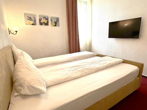 a bedroom with two beds and a flat screen tv at Hotel TISA in Băile Olăneşti