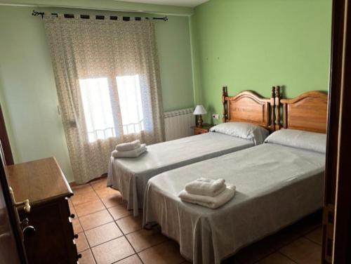 1 dormitorio con 2 camas y toallas. en Hotel El Cid, en Torres de Albarracín