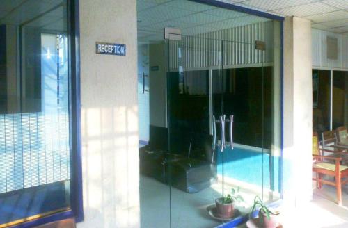 a swimming pool in a building with a glass door at Mughal Hotel in Sargodha