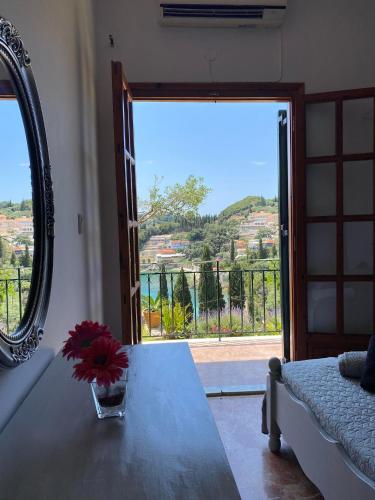 a room with a table with a vase of flowers on it at Teo & Niki in Paleokastritsa
