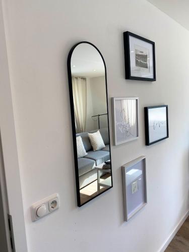 a mirror on a wall with a chair and pictures at Penthouse - Zentral und Genial in Passau