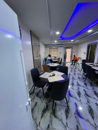 a dining room with tables and chairs and blue lights at Masters Class Hotels and Apartment in Uyo