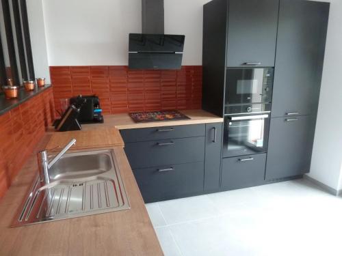 une cuisine avec un évier et une cuisinière dans l'établissement Soleil & mer sur la Costa Verde, à Cervione