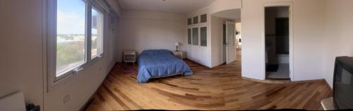 1 dormitorio con cama azul y ventana grande en Belgrano Apart en Santiago del Estero