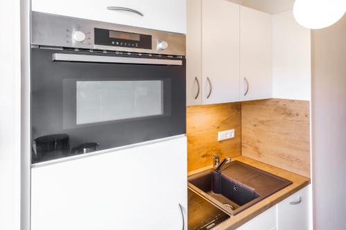 una cucina con fornelli e lavello di Chiemgau Comfort C6 Ferienwohnanlage Oberaudorf mit Hallenbad und Sauna a Oberaudorf