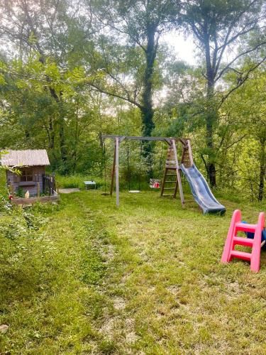 a playground with a slide and a swing set at Cabane dans les bois in Sumène