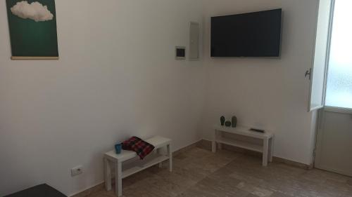 a room with two tables and a tv on a wall at Alla marina in Fiumefreddo di Sicilia
