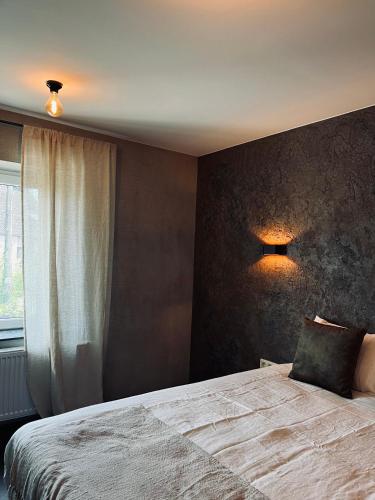 a bedroom with a large bed and a window at La Grainerie in Durbuy