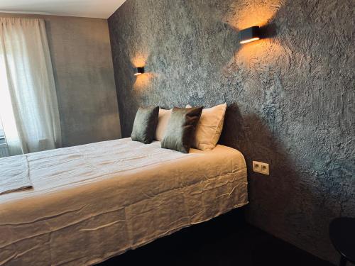 a bedroom with a bed with two pillows on it at La Grainerie in Durbuy