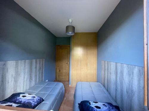 a bedroom with two beds and a blue wall at Casa Mati in Sorripas