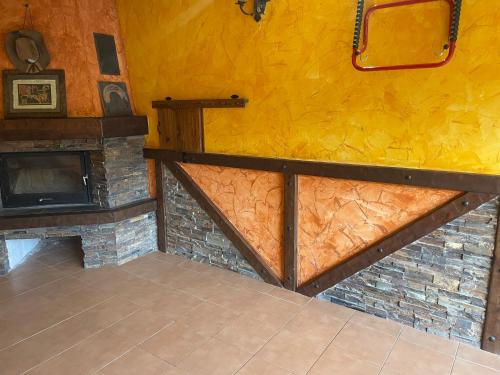 a living room with a stone fireplace and yellow wall at Casa Mati in Sorripas