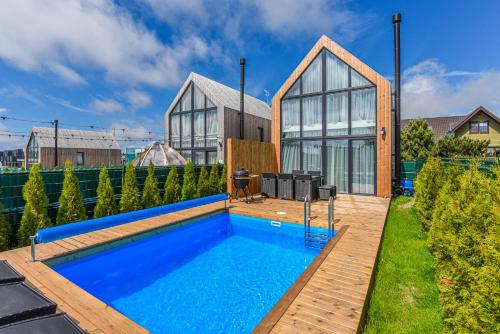 una casa con piscina nel cortile posteriore di DREAM HOUSE PALANGA WITH PRIVATE SWIMMING POOL, Hot Tub and Sauna a Palanga
