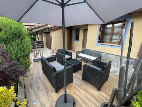 a patio with chairs and an umbrella on a deck at Casa Mati in Sorripas