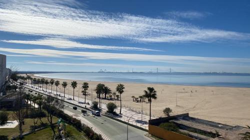 vistas a una playa con palmeras y a una carretera en La ilusión de Pepa, en El Puerto de Santa María