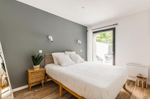 une chambre avec un grand lit et une fenêtre dans l'établissement CHILL HAVEN - Jacuzzi & Cinéma - Queen Size - Parking - Terrasse, à Saint-Étienne