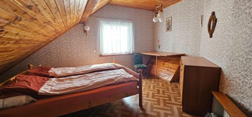 ein Schlafzimmer mit einem Bett und einer Holzdecke in der Unterkunft Domek na Kaszubach in Bieszkowice