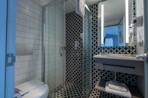 a bathroom with a shower and a toilet and a sink at The Row Taksim Hotel in Istanbul