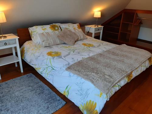 un letto in una stanza con due comodini e due tavoli di Casa da Ribeira a São Vicente