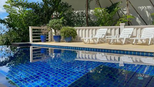 una piscina con sillas, una mesa y una piscina en Villa Mauao - Luxury Villa in Katamanda, Kata, en Kata Beach