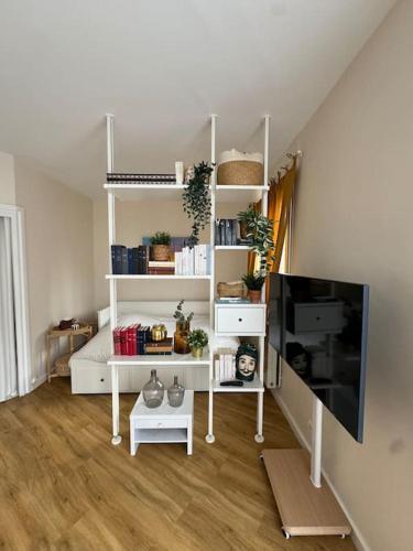 un salon avec des étagères blanches et une télévision à écran plat dans l'établissement Suite Paris Tour Eiffel, à Paris