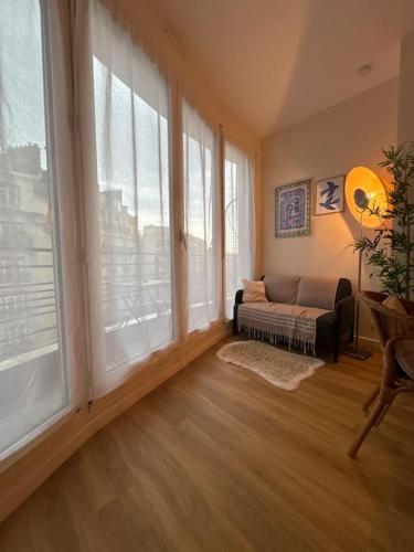 - un salon avec un canapé et de grandes fenêtres dans l'établissement Suite Paris Tour Eiffel, à Paris