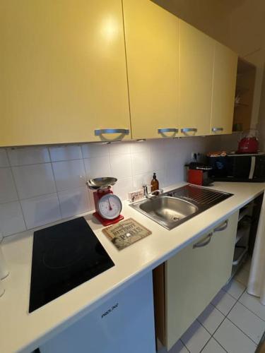 - un comptoir de cuisine avec un évier et un réveil dans l'établissement Suite Paris Tour Eiffel, à Paris