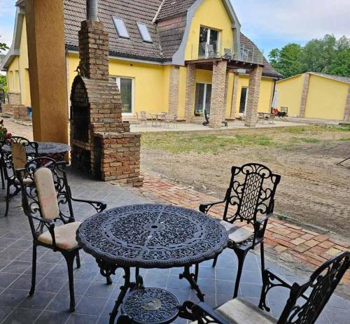un patio con mesa y sillas frente a una casa en Einzelzimmer am Hegensteinbach en Ravensbrück