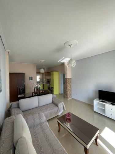 un soggiorno con un divano e un tavolo di Anna Apartments a Sarandë