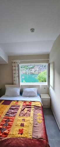 1 dormitorio con 1 cama y ventana grande en koman_lakeview_apartments, en Shkodër