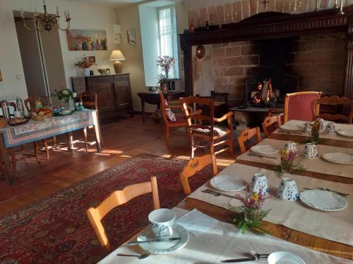 une salle à manger avec une table et une cheminée dans l'établissement La Vieille Auberge, à Peyrelevade