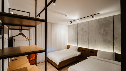 um pequeno quarto com 2 camas e uma secretária em BAZ'HUR Boutique Hotel em Kukës