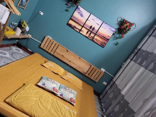 1 dormitorio con 2 camas y pared azul en Golden Bell Backpacker Hostel, en Ninh Binh