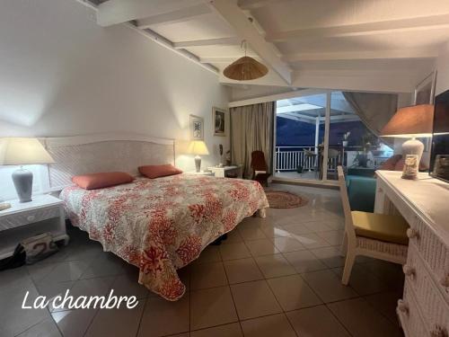 a bedroom with a bed and a balcony at La Case à Méline in Le Gosier