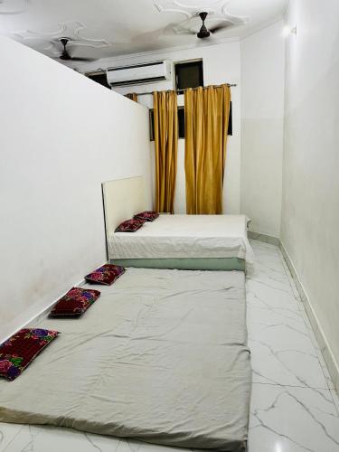 two beds in a small room with curtains at Hotel MK Lawn in Bareilly