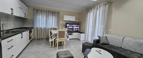 cocina y sala de estar con sofá y mesa en koman_lakeview_apartments, en Shkodër