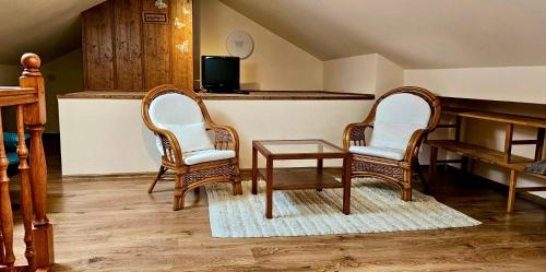 dwa krzesła i stół w pokoju w obiekcie Apartament Pers - Odkryj luksus, który spełni Twoje oczekiwania w Szczawnie Zdroju