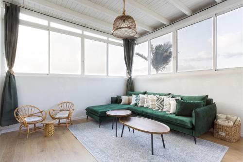 ein Wohnzimmer mit einem grünen Sofa und einem Tisch in der Unterkunft שלווה בגלבוע in Gid‘ona