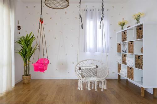 a room with a white chair and a plant at שלווה בגלבוע - וילה מהממת עם ג'קוזי ובריכה בגדעונה in Gid‘ona