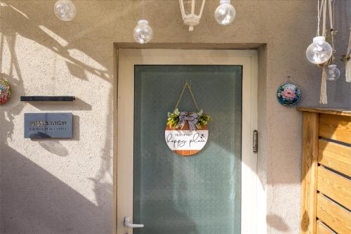 eine Tür mit einem Topf mit einem Schild drauf in der Unterkunft שלווה בגלבוע in Gid‘ona