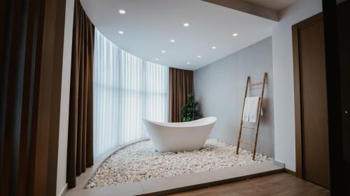 uma banheira sentada num quarto com uma janela em BAZ'HUR Boutique Hotel em Kukës