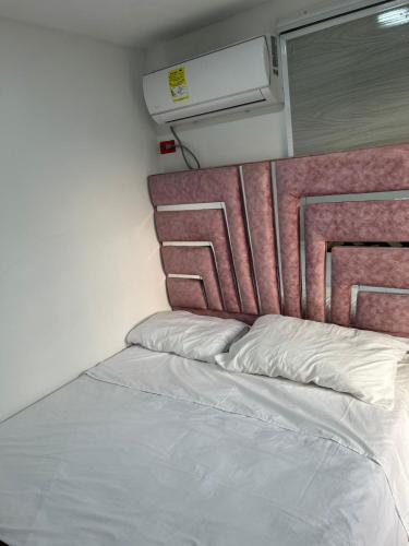 - un lit avec des oreillers blancs dans l'établissement Habitaciones villa oti, à Ciénaga