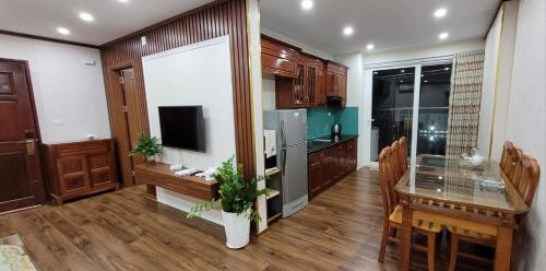 a kitchen and dining room with a table and a television at Homestay Ha Long Luxury Apartment ( Ocean View) in Ha Long