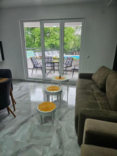 sala de estar con sofá, mesas y patio en Drinski Zamak, en Vrhpolje