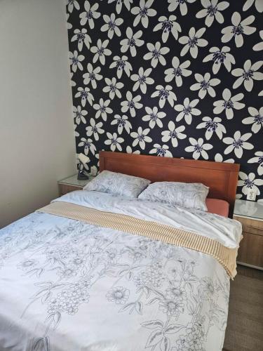 Un dormitorio con una cama con papel pintado floral. en Drinski Zamak, en Vrhpolje