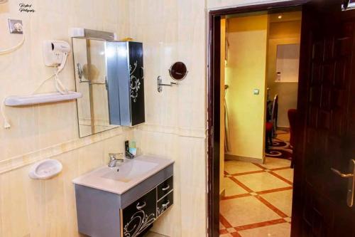 a bathroom with a sink and a mirror at Hôtel LE PÉRIDOT in Brazzaville