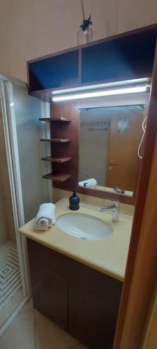 a bathroom with a sink and a mirror at Amdar Village Cottage עם ממ"ד in Eilat
