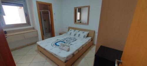 a small bedroom with a bed and a window at Amdar Village Cottage עם ממ"ד in Eilat