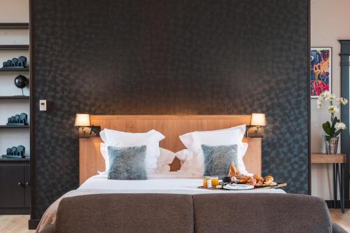 a bedroom with a bed with a tray of food on it at Le Monastère de Saint Mont Hôtel & Spa in Saint-Mont