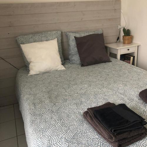 un lit avec deux oreillers dessus dans l'établissement Studio terrasse, à Les Sables-dʼOlonne